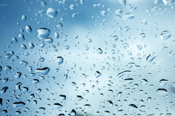 rain drops on glass blue sky and gloomy weather beautiful sky background