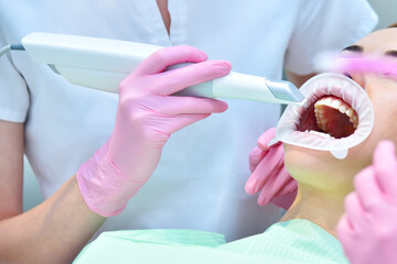 Dentist scaning patient's teeth with intraoral 3d scanner