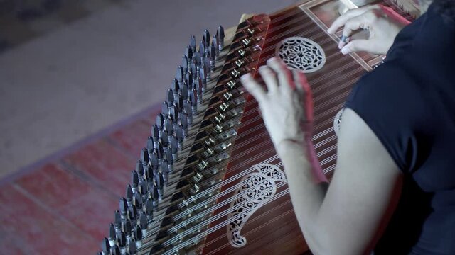 The fingers of a woman who plays an ancient oriental musical instrument - eve. The technique of using a stringed musical instrument.