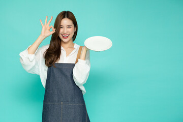 Restaurant owner sme Asian woman showing OK sign and holding empty white plate or dish isolated on...