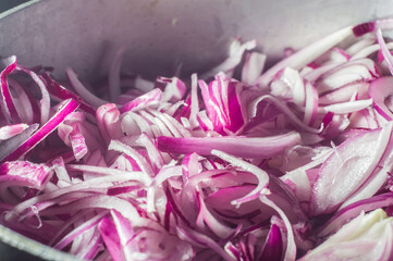 red onion in an aluminum pan, street in the background