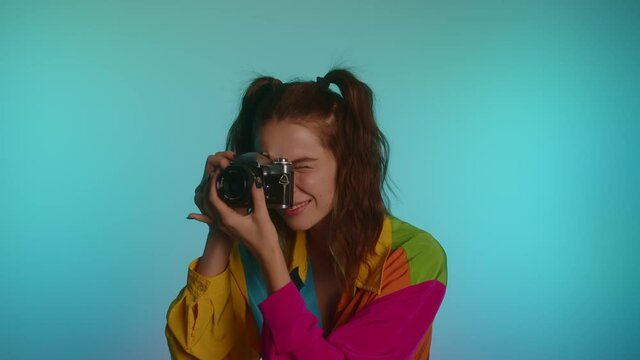 Cheerful Woman Wearing Colorful Jacket Having Fun On Taking Pictures With Camera. - medium shot