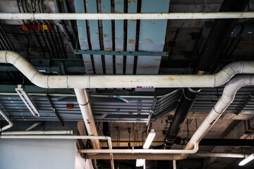 Naklejka premium Electrical conduits system and metal pipeline installed on building ceiling.