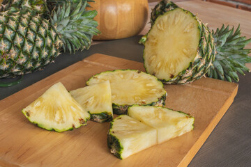 Slices of pineapple on the wooden cutting board. Pineapple is a tropical fruit healthy and very juicy. They have sweet and sour taste. Pineapple is from South America now is the world famous fruit.