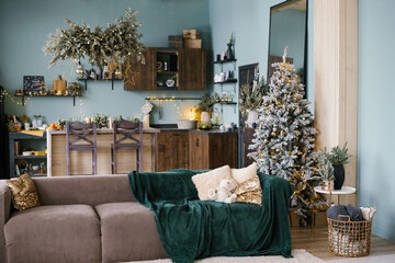 Blue and emerald Christmas interior. Living room with blue walls, dusty brown sofa and an emerald blanket