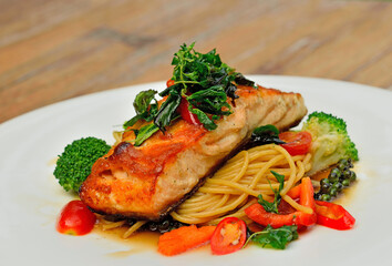 Baked Salmon steak with spaghetti on white plate