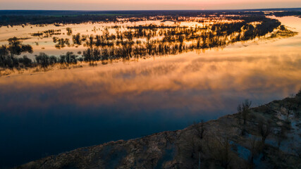 Aerial atmospheric view on big river. Aerial drone view of river landscape in sunny sunset. Nature concept.