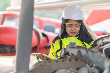 Technician fixing the engine of the airplane,Female aerospace engineering checking aircraft engines,Asian mechanic maintenance inspects plane engine