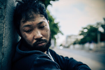 Asian man is homeless at the side road,A stranger has to live on the road alone because he has no family.