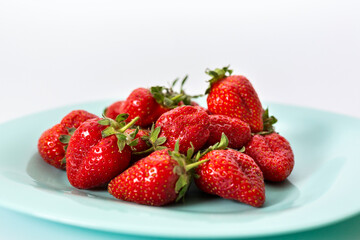 Delicious red strawberries, isolated on a plate. Background texture.
