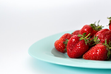 Red strawberries on a plate. Isolated on a white background.