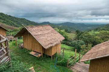 Wooden thatched hut resort on hill among mountain in tropical rainforest
