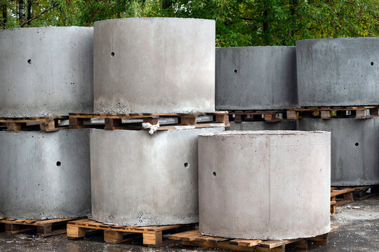 Reinforced concrete rings of a well or sewer in outdoors. Industrial production structures at store's trade exhibition. Reinforced concrete products on construction site.