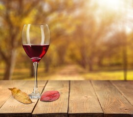 Wine glass with red wine and autumn leaves. Creative wine degustation