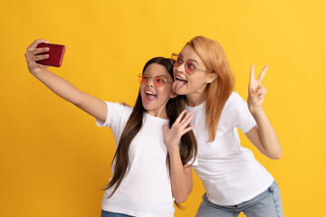 funny mom and kid making selfie on smartphone, portrait
