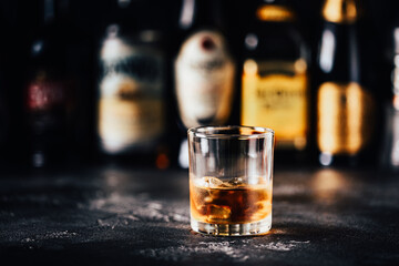 Whiskey with ice on a dark table