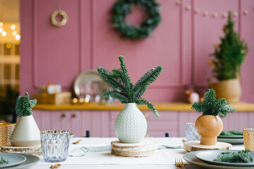 Fresh fir branches or pines in a ceramic vase, a vase on the kitchen table in decorated for Christmas and New year.