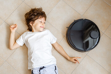 Kid playing with Robot Vacuum Cleaner on the floor