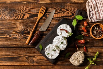 Camembert cheese on a rustic background. Noble cheese with mold. An overhead view of cheese with...