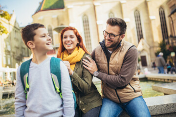 Young parents taking their little child to school