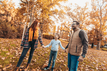 Portrait of a happy family having fun in the autumn park.