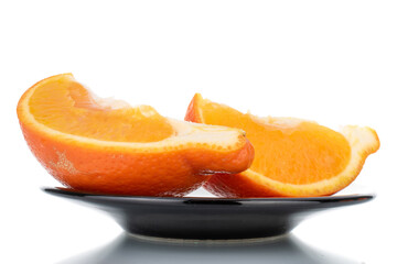 Two slices of organic ripe minneola on a ceramic dish, close-up, isolated on white.