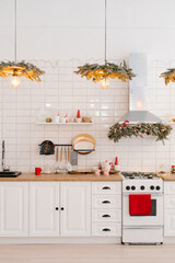 Kitchenware and decor on a white shelf in a cozy kitchen with lights. Christmas home decoration