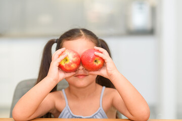 Healthy food for children. Funny image of little girl showing two apples.