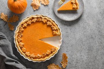 American Pumpkin Pie served on gray stone table with copy space. View from above. Thanksgiving Day festive seasonal dessert.
