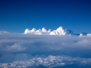 Obraz premium View from an airplane porthole to the beautiful white clouds and clear blue sky