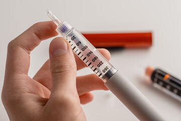 medicine, diabetes, glycemia, healthcare and people concept - close-ups of man's hands. Medical devices are used for self-injection to treat diabetes. World Diabetes Day and the concept of health care