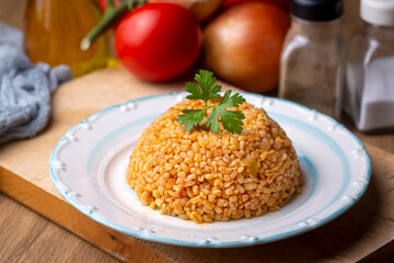 Traditional turkish bulgur pilaf with tomato sause in plate (Turkish name; meyhane pilavi)