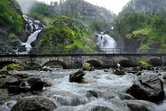 A beautiful landscape with a bridge by the Latefossen Waterfall and Espelandsfossen Waterfall in Norway