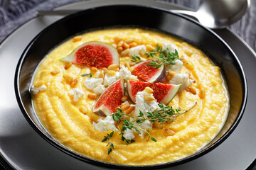 Pumpkin cream soup with thyme with feta and figs