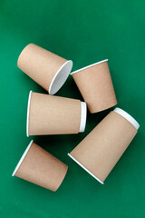 empty paper cup to go against green background
