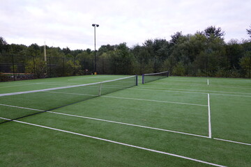 Tennis court with green turf background.