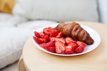 Freshly baked croissant  with strawberries at a home for breakfast