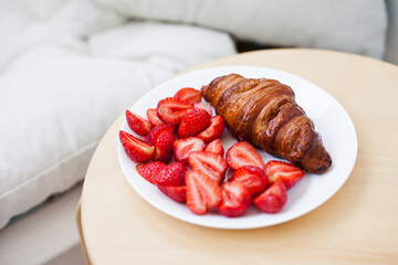 Freshly baked croissant  with strawberries at a home for breakfast