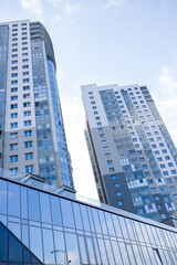 Fototapeta na wymiar Tall buildings in the city against the blue sky, urban high-rise buildings.