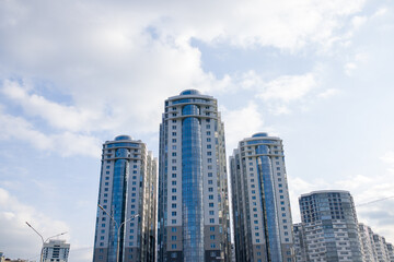 Fototapeta na wymiar Tall buildings in the city against the blue sky, urban high-rise buildings.