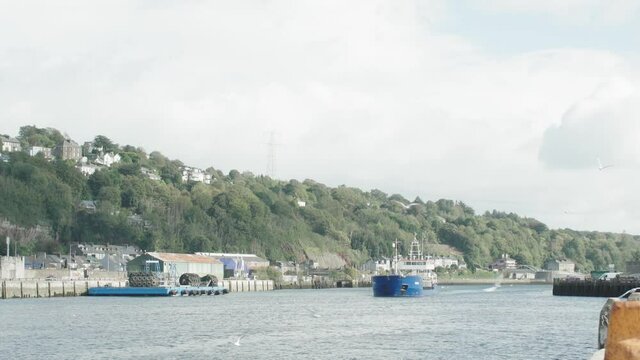 A large cargo ship enters cork city Port of Cork in Ireland and docks on the quay