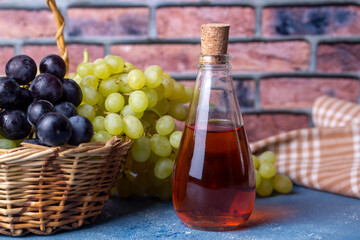 Wine vinegar in a glass jug, dark vintage wooden background, selective focus