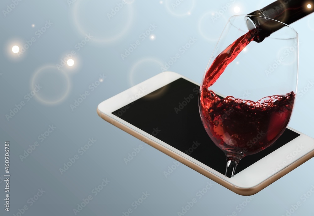 Wall mural Modern artwork. Glass filling with wine from a bottle in phone screen