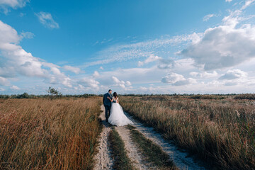Obraz premium bride and groom newlyweds at the sea. lovely young couple, woman in wedding dress and man in suit by the sea or ocean are spending their honeymoon