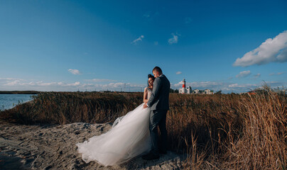 bride and groom newlyweds at the sea. lovely young couple, woman in wedding dress and man in suit by the sea or ocean are spending their honeymoon