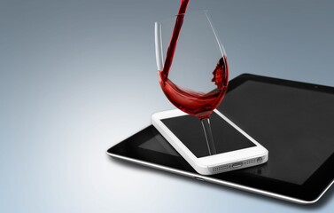 Modern artwork. Glass filling with wine from a bottle in phone screen