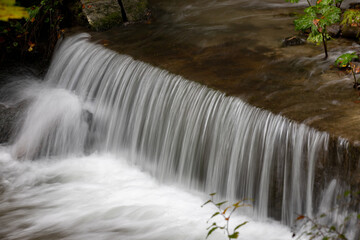 Fototapeta na wymiar a waterfall on a stream in the woods