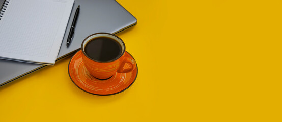 cup of coffee, laptop on a colored background