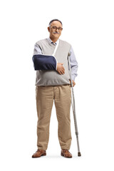 Full length portrait of a mature man with a broken arm wearing a splint and standing with a crutch