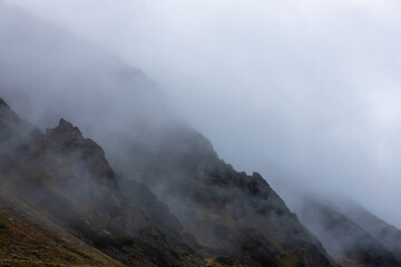 a beautiful landscape with fog on the mountain slope